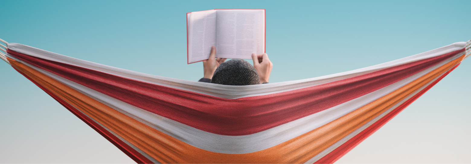 Une personne lit un livre dans un hamac